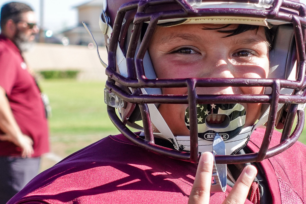 Teen football player smiling.